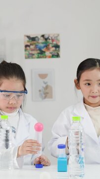 Asian Schoolgirls in Lab Coats Perform Bernoulli's Principle Science Experiment