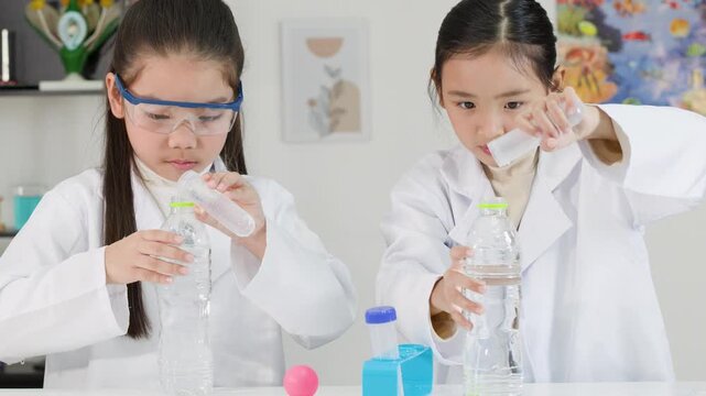 Asian Schoolgirls in Lab Coats Conduct Bernoulli Principle Science Experiment