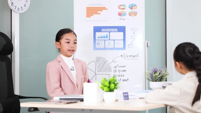 Young Asian Girl in Pink Blazer Giving Business Presentation in Office