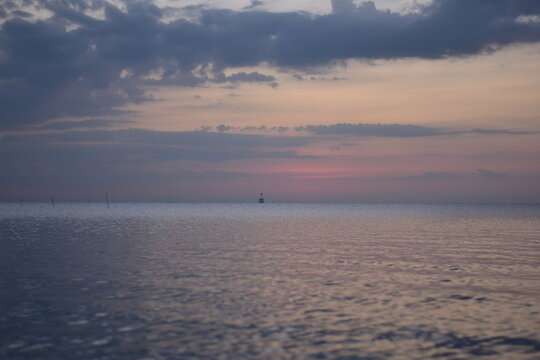 Sunset over the beach with boats in the background