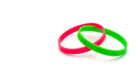 Naklejka premium Vibrant interlocking rubber bands in red and green, isolated on a white background, symbolizing connection and unity.
