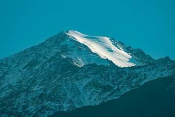 Majestic Mountain Peak with White Glacier and Clear Blue Sky with copy space.