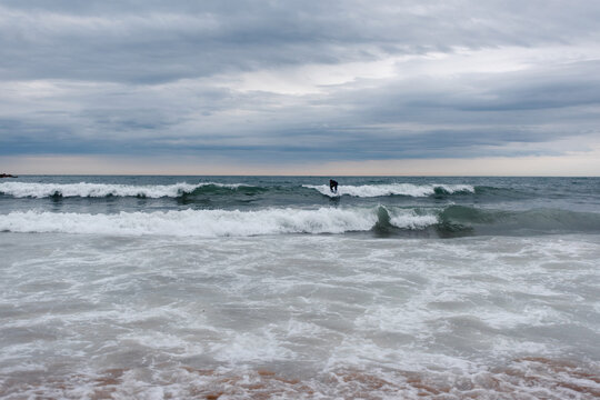 Lone surfer braves choppy waves at Barcelona's beach