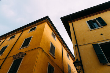 Obraz premium Buildings in Riva del Garda with yellow walls and dark shutters