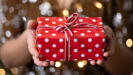 Gifting Moment: Hands Presenting Star-Printed Red Gift Box Against Warm Bokeh Lights &mdash; Celebration, Gratitude & Thoughtful Exchange Concept