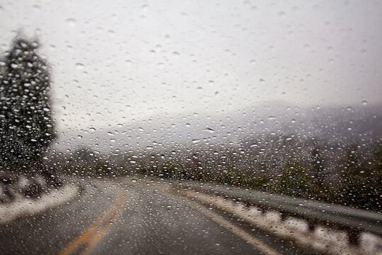 Raindrops on windshield on two lane highway.