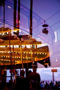 Amusement Park, Santa Cruz, reflectio of a roundabout ride in a funfair at dusk, unrecognizable people.