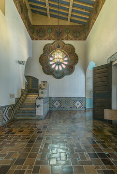 Santa Barbara, the County Courthouse built in the 1920s in the Spanish Colonial Revival architectural style, the interior hallway, painted panels and beams, stairs, a rose window and tiled walls.