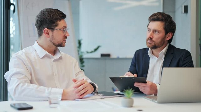 Dedicated business individuals engage in focused discussion. Professional collaboration and strategic planning create an atmosphere of concentration and determination for project success.