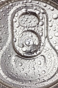 Macro view of water droplets covering the top of a sealed aluminum beverage can. Cold, fresh, and ready-to-drink concept.