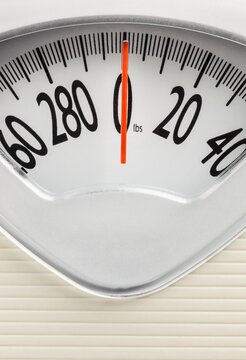 Analog bathroom scale with red needle pointing at zero. Clean, minimal concept for fitness, weight tracking, or health themes.