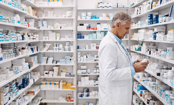Medicine, mature man and pharmacist at dispensary in pharmacy for stock, inventory or order. Medication, pharmaceutical and male healthcare worker with pills for medical prescription at chemist.