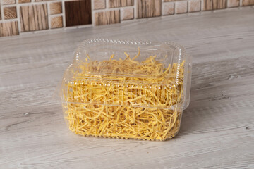 Package of dry spaghetti placed on a kitchen counter at home during daytime