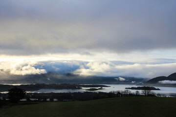 Obraz premium Dramatic clouds over lake and mountains at sunset