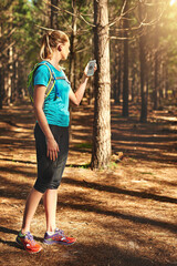 Naklejka premium Woman, fitness and checking with phone for compass, hiking direction or location in forest. Active, female person or runner with mobile smartphone or tracking app in woods for trekking path or route