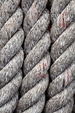 Detailed close-up of thick, weathered rope at a marina in Bandon, Oregon, showing texture and wear.