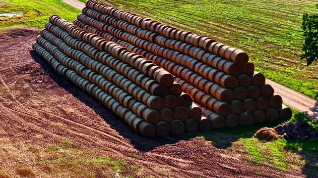 Aerial: stack of stacked hays in a field during the day, outdoor, establishing drone shot