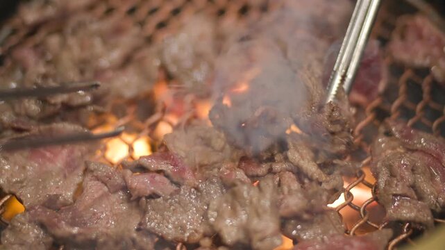 Slow motion video of Griling Korean traditional BBQ bulgogi on the grill