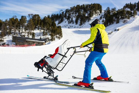 Ski instructor assisting child with cerebral palsy in adaptive skiing