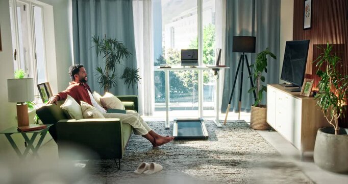 Man, relax and watching tv on sofa with smile, streaming service and entertainment on weekend break. Happy, person and comfortable in home with movie, network and cable subscription for film series.