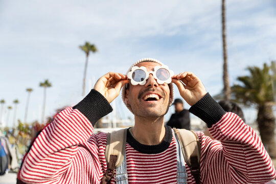 Playful customer enjoying flower shaped sunglasses at Barcelona flea market