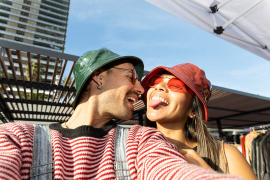 Cheerful couple taking outdoor selfie in urban summer setting