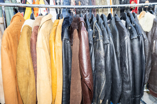 Vintage leather jackets on hangers in row at second hand clothing shop