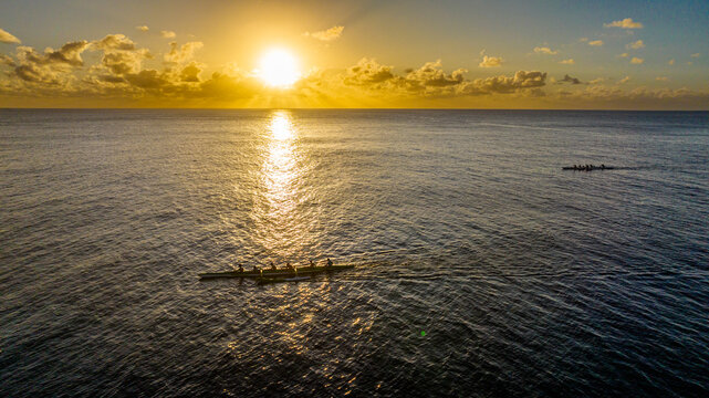 Rowing competition at sunset on the ocean in Rurutu French Polynesia