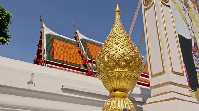 Shining finial perched against sunlight with tiled roof background Wat Phra Kaew