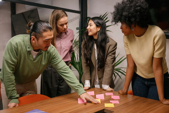 Business team brainstorming with notes and laptop at office meeting