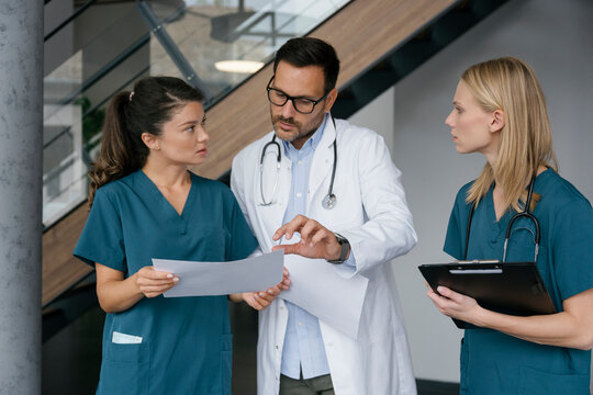 Doctor and nurses discussing documents in hospital