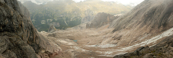 Panoramic view of steep limestone basin with glacial lake in Dolomites mountains Italy