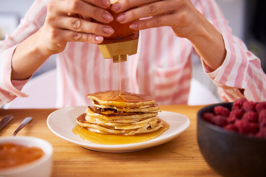 Young woman having sweet pancakes for breakfast, close up