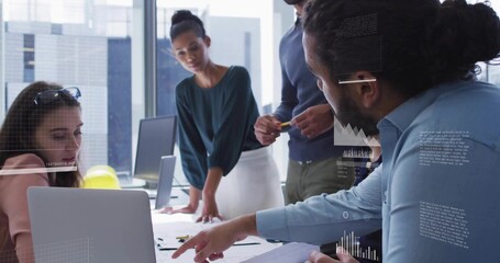 Collaborating team in blazers discussing at table in glass office with laptop documents overlays © vectorfusionart