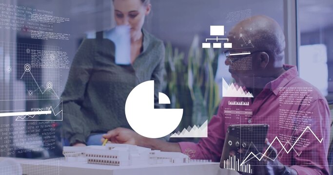 Pointing two colleagues in office attire studying scale model with tablet and data charts in office