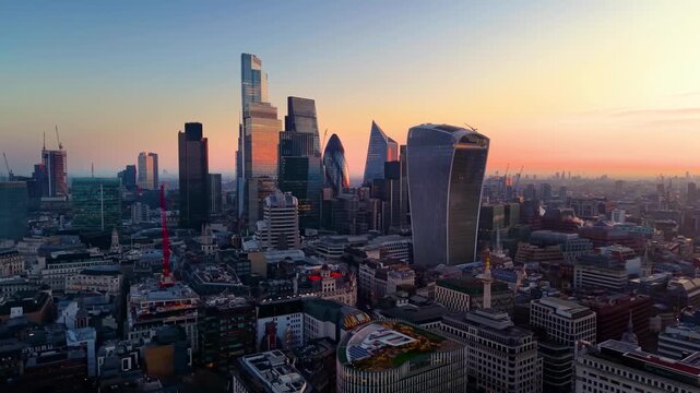 Panoramic aerial view of the City of London cluster skyline during a golden sunrise