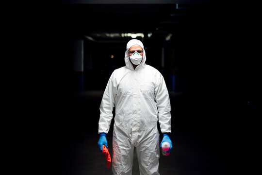 Cleaning staff in suit with sanitizer and cleaning cloth