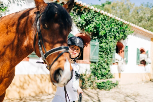 Teenager with down syndrome taking care of horse and preparing horse to ride