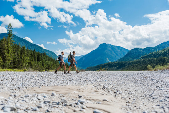 Germany, Bavaria, two hikers walking in dry creek bed