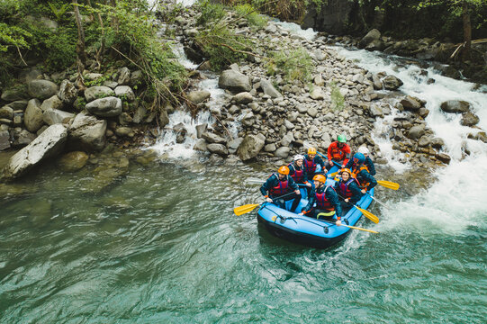 Group of people rafting in rubber dinghy on a river