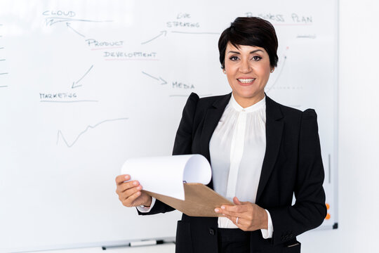 Portrait of businesswoman posing with documents in hands