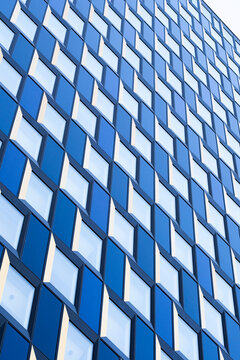 Blue glass windows on modern skyscraper facade create geometric pattern with crisp reflection for abstract architecture background