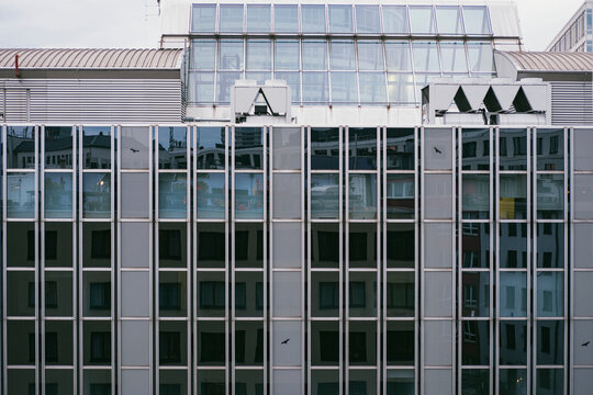 Glass windows on a modern office building exterior create an urban grid facade for clean architecture detail and corporate building background