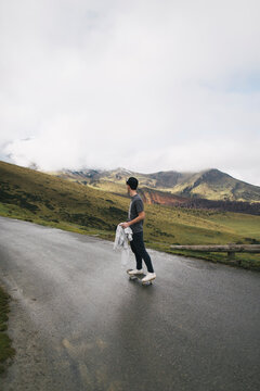 Spain, Lleida, young man on skateboard in rural landscape