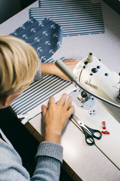 Woman using sewing machine on table in studio