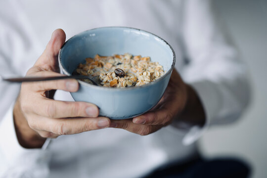 Man's hands holding cereal bowl, close-up