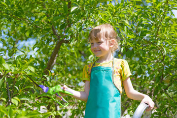 Child gardening outdoors with tools in green garden