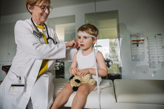 Pediatrician measuring extent of child?s head