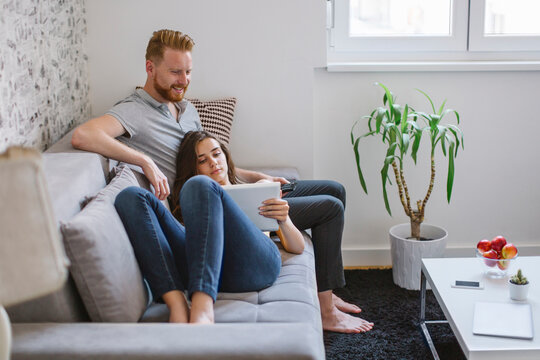 Couple on the sofa in the living room using tablet