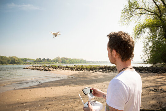 Man flying drone at a river